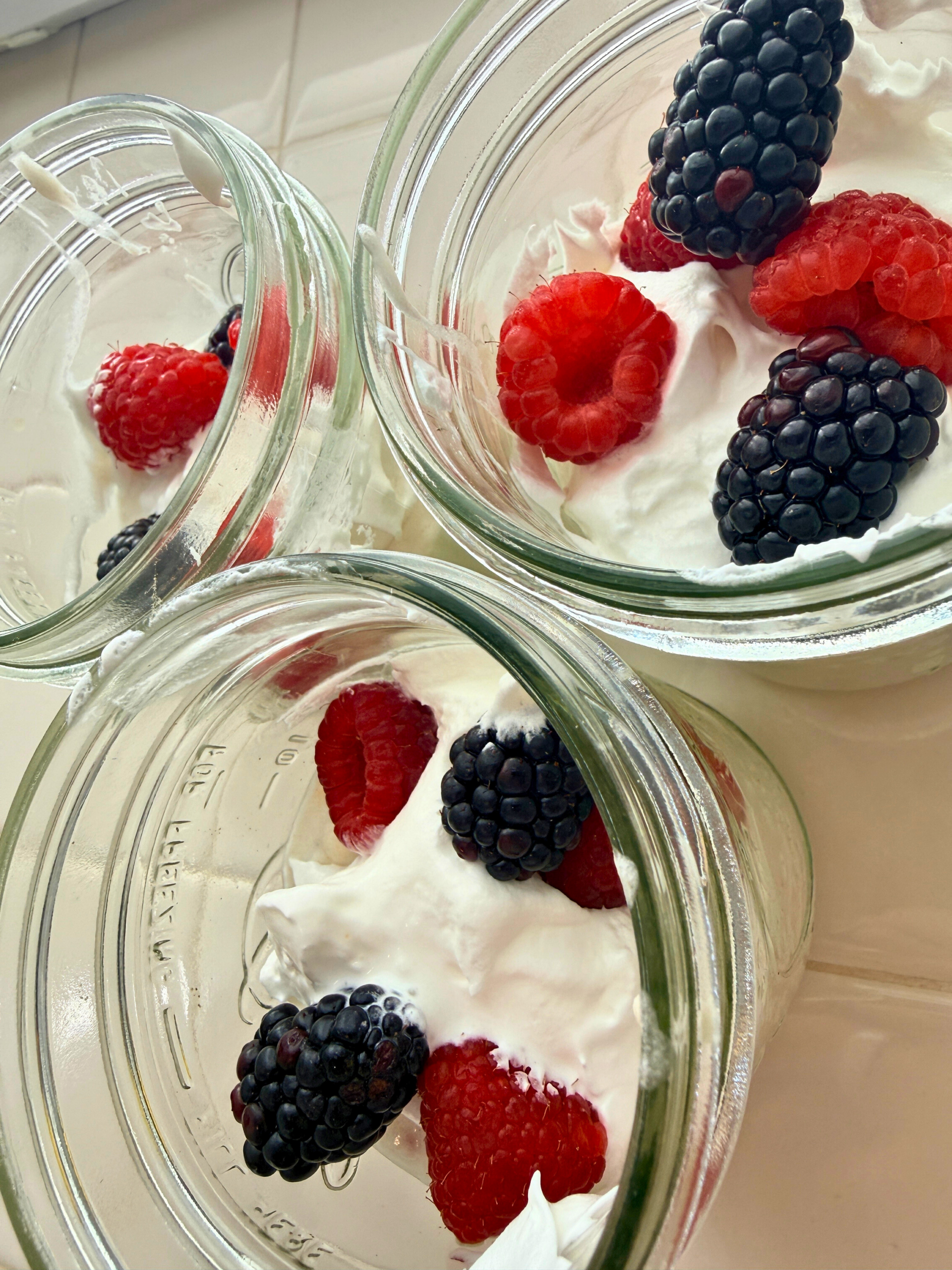 funfetti pudding cups with whipped cream, raspberries, blackberries on top