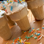 icecream cone cupcakes with white icing and multi colored sprinkles